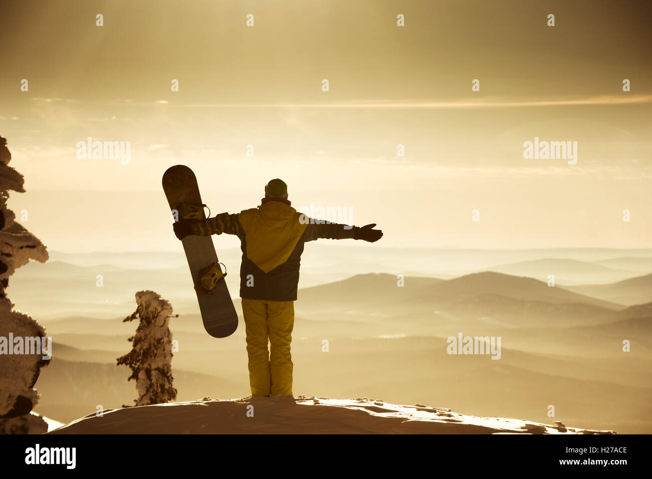 Snowboarder posing on blue sky backdrop in mountains fog Stock Photo