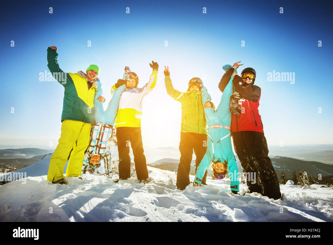Snowboarders posing on blue sky backdrop in mountains skiing Stock Photo