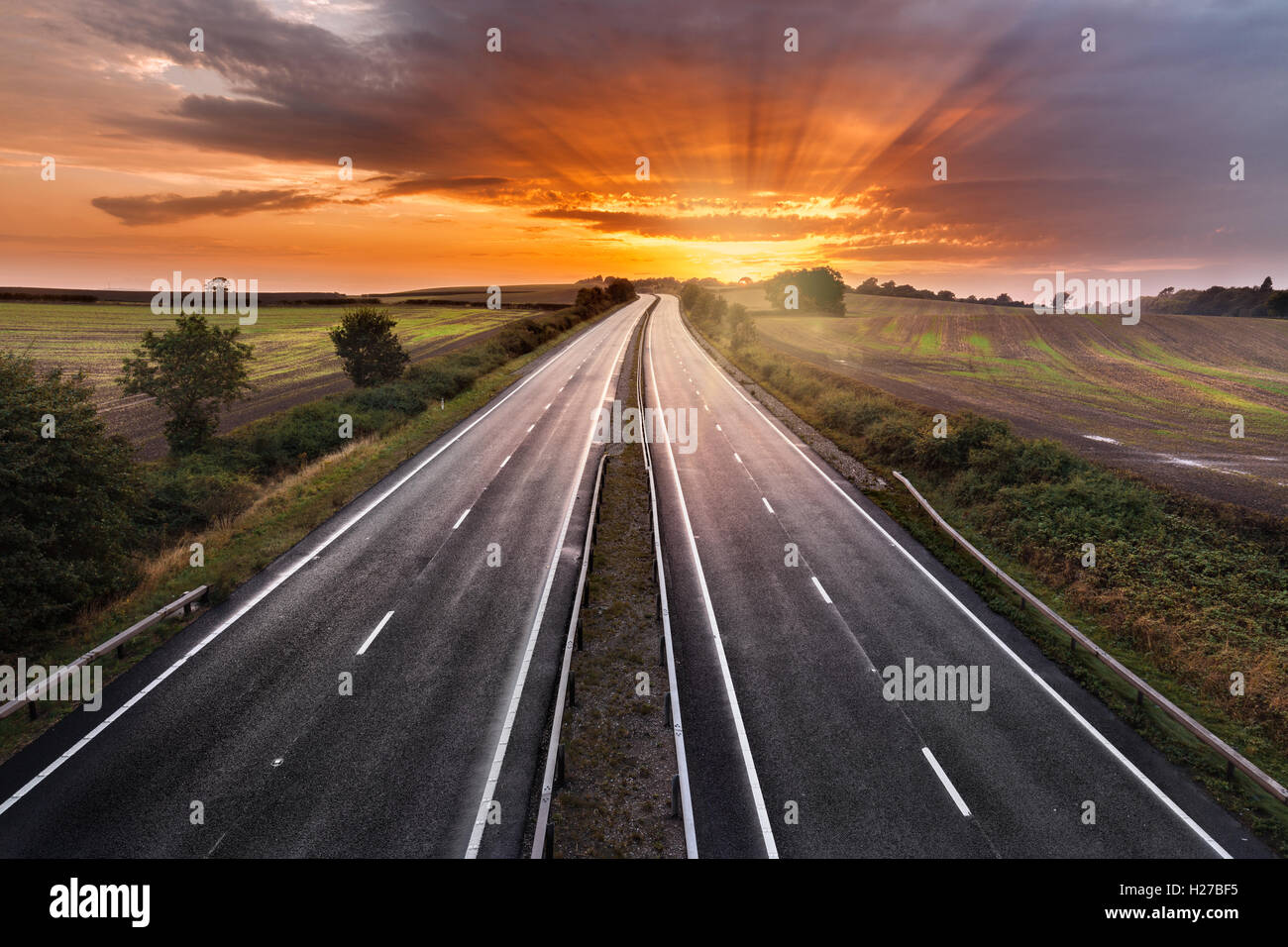 Sunset Sky over Empty Asphalt Road of Dual Carriage Motorway Stock Photo