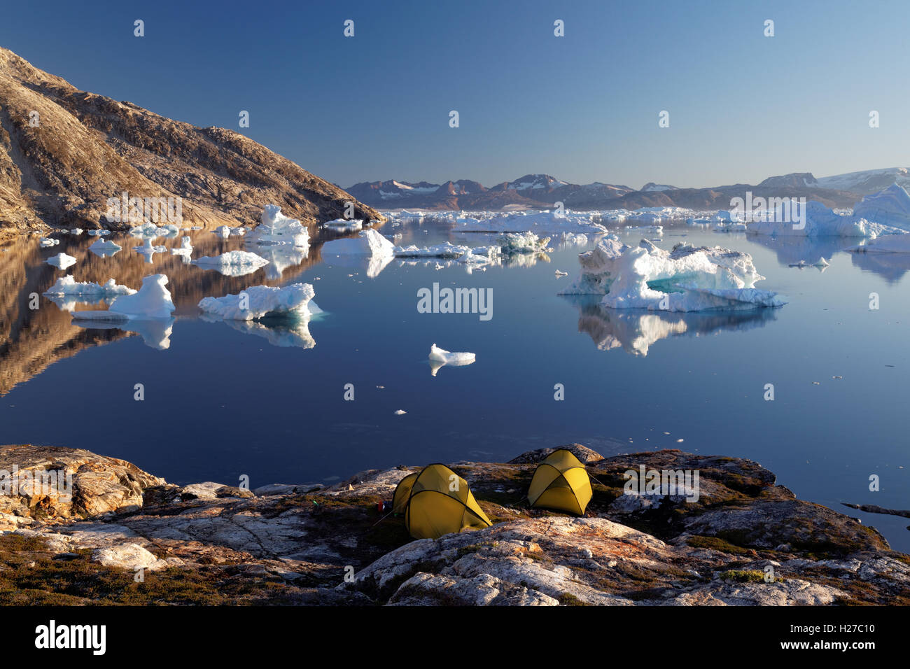 Icebergs and sea kayaker's camp on edge of Sermilik Fjord near settlement of Tiniteqilaq, East Greenland Stock Photo