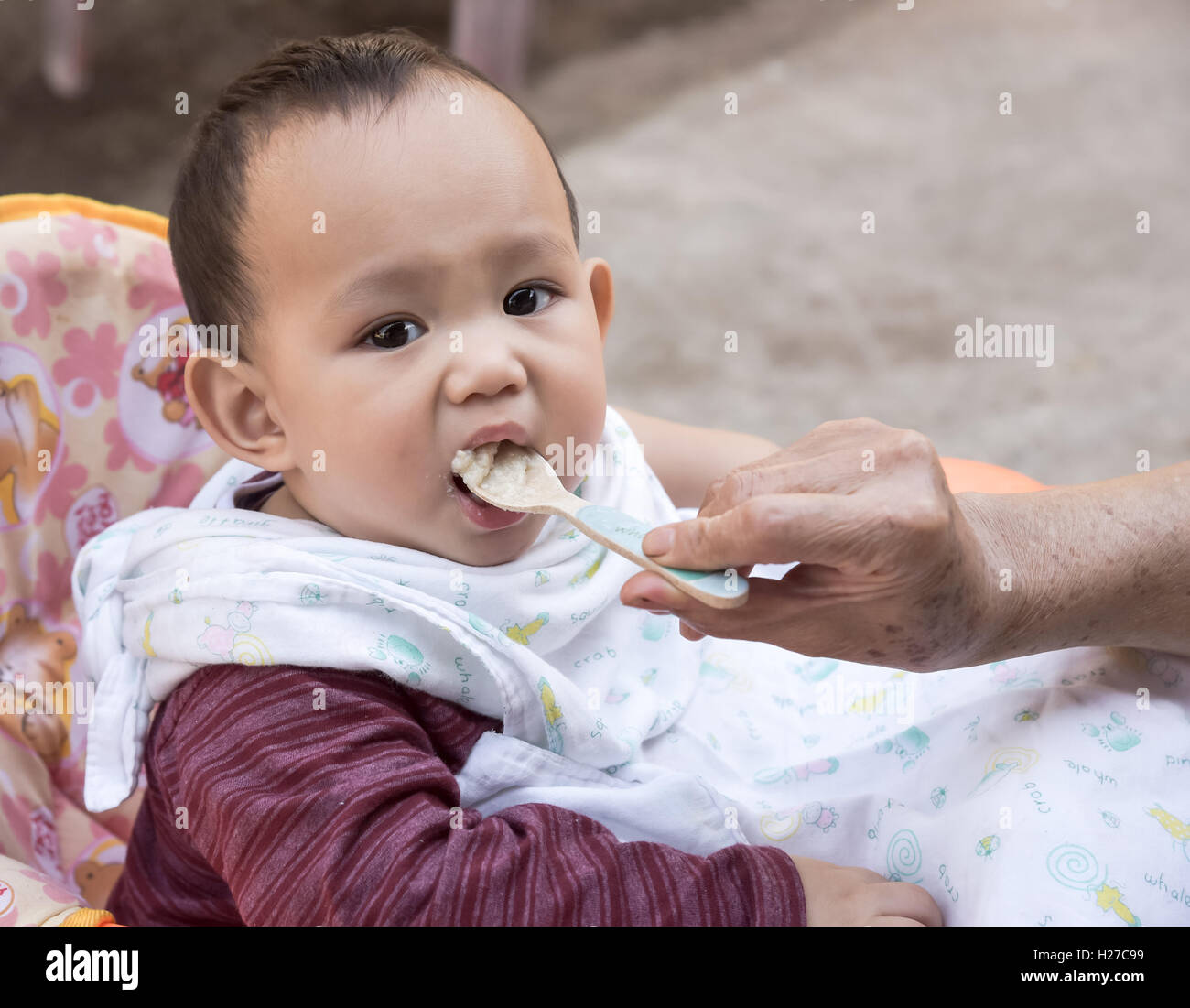 Baby eating food by mother feeding, family scene of Thailand Stock Photo Alamy