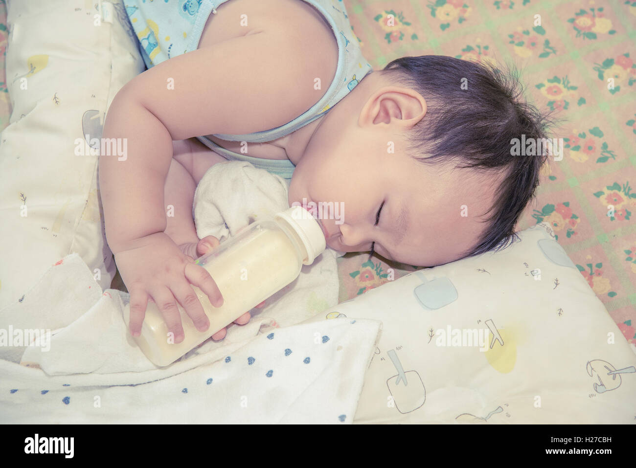 Asian baby sleeping and drinking milk from the bottle Stock Photo