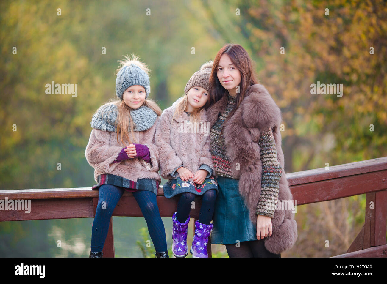 Adorable little girls and young mother in autumn park outdoors Stock ...