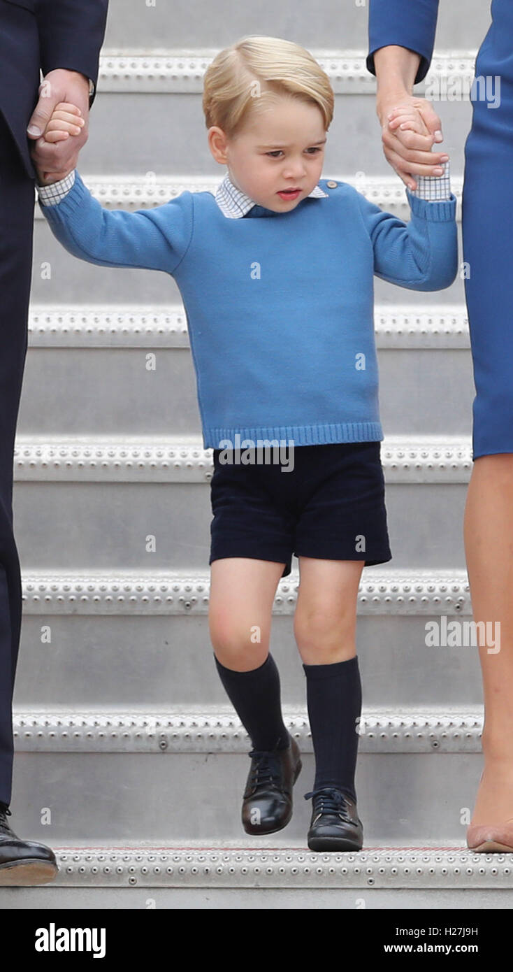 Prince George holds hands with his parents the Duke and Duchess of Cambridge as he walks down the aircraft steps as the Royal Party, including his sister Princess Charlotte, arrive at Victoria International Airport, in Victoria, Canada, on the first day of their official tour of Canada. Stock Photo