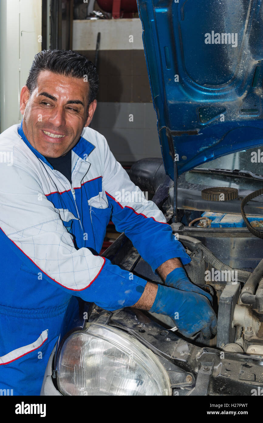 Car mechanic fixing an engine in his garage. copy space Stock Photo Alamy