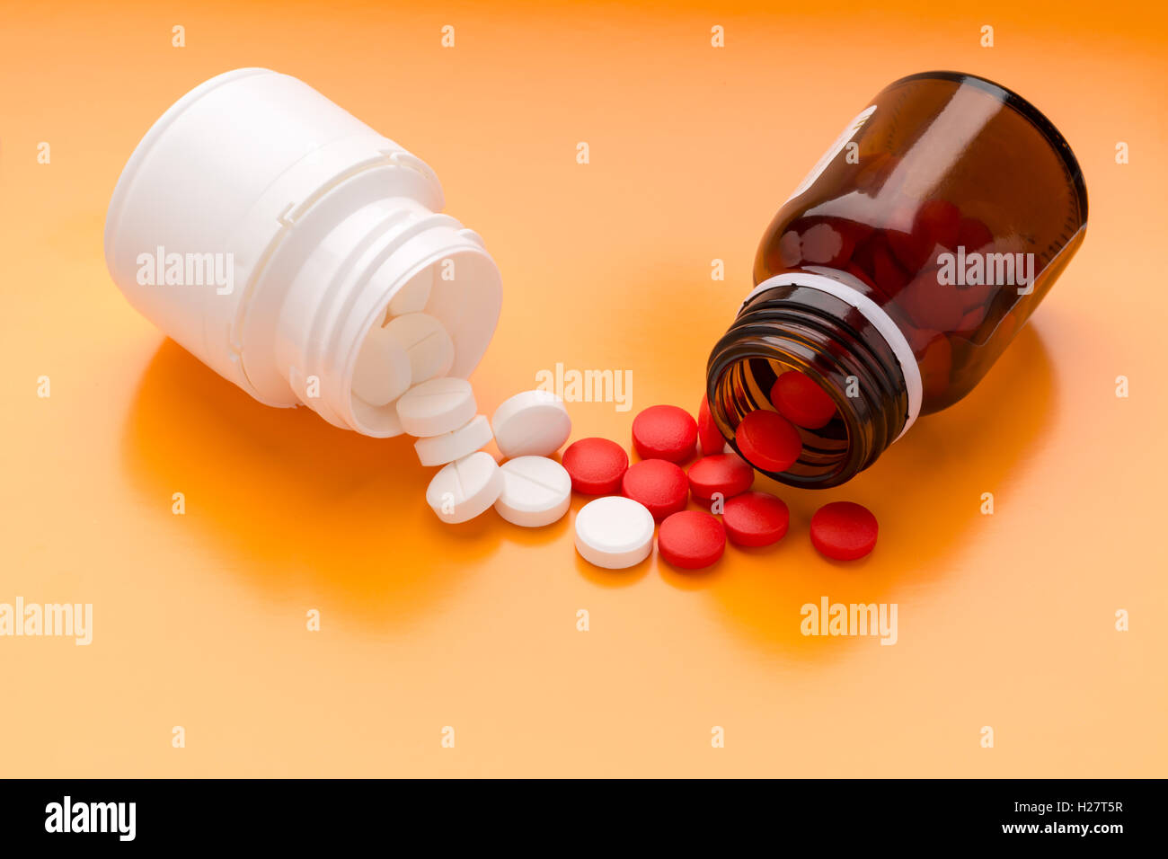 Round white pills and plastic pill bottle Stock Photo