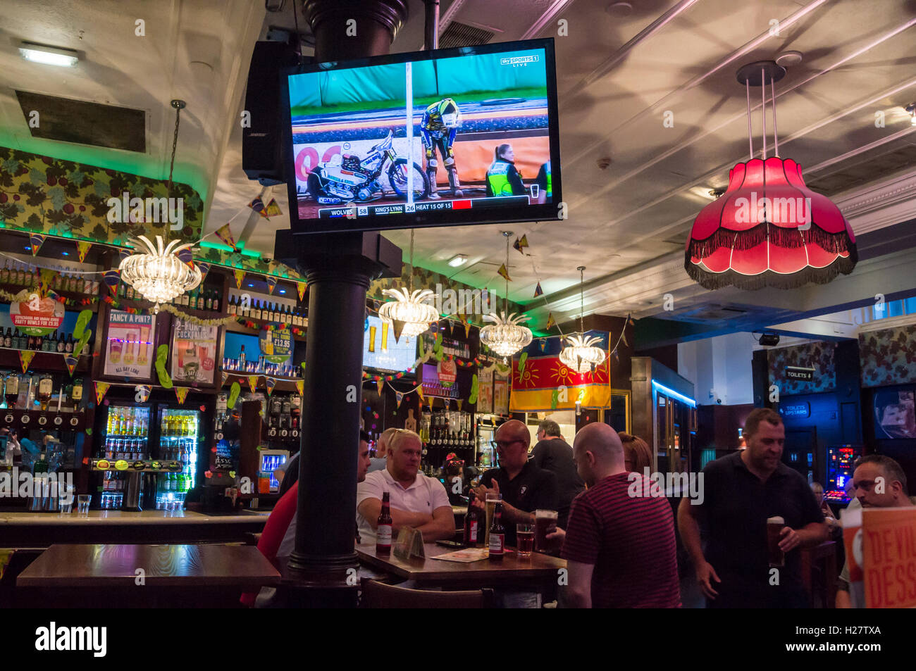 Men watching speedway motorcycle racing on a largescreen television at Yates's Wine Lodge