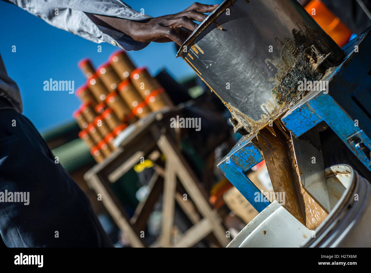 A man makes peanut butter for sell at the market in Lusaka, Zambia Stock Photo