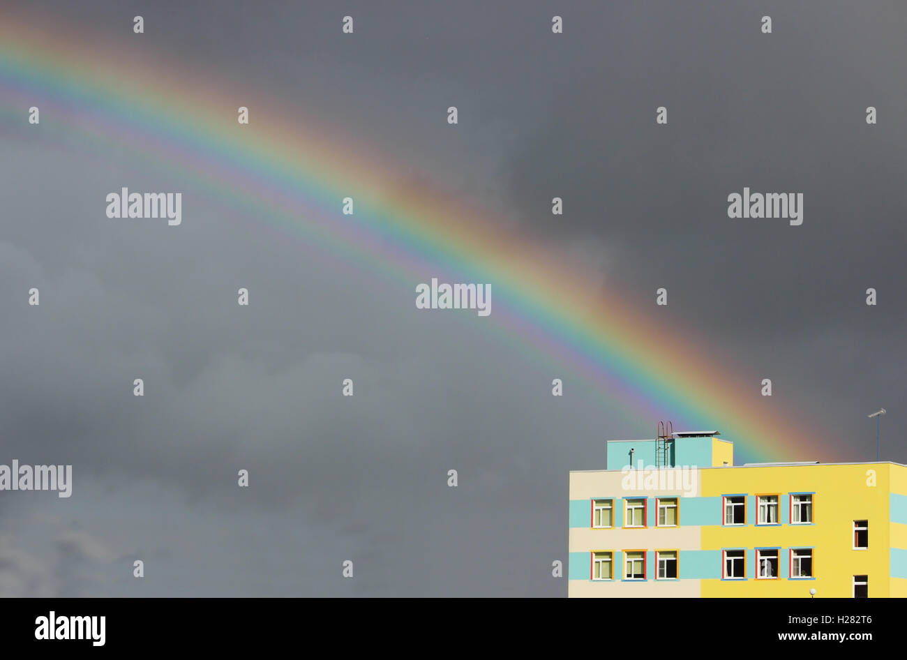 Bright multi-colored wide colorful rainbow after the storm in the gray ...