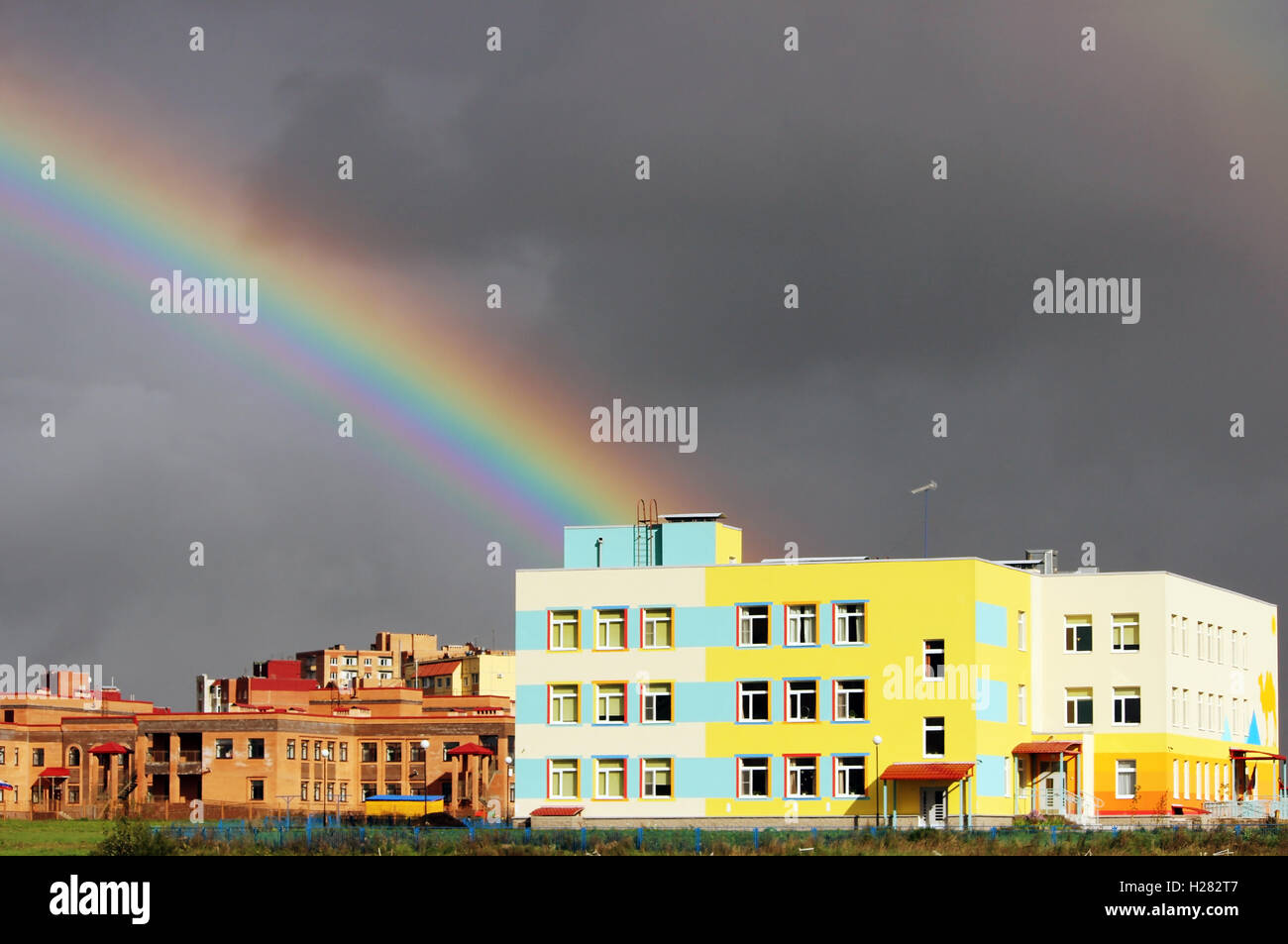 Bright multi-colored wide colorful rainbow after the storm in the gray ...