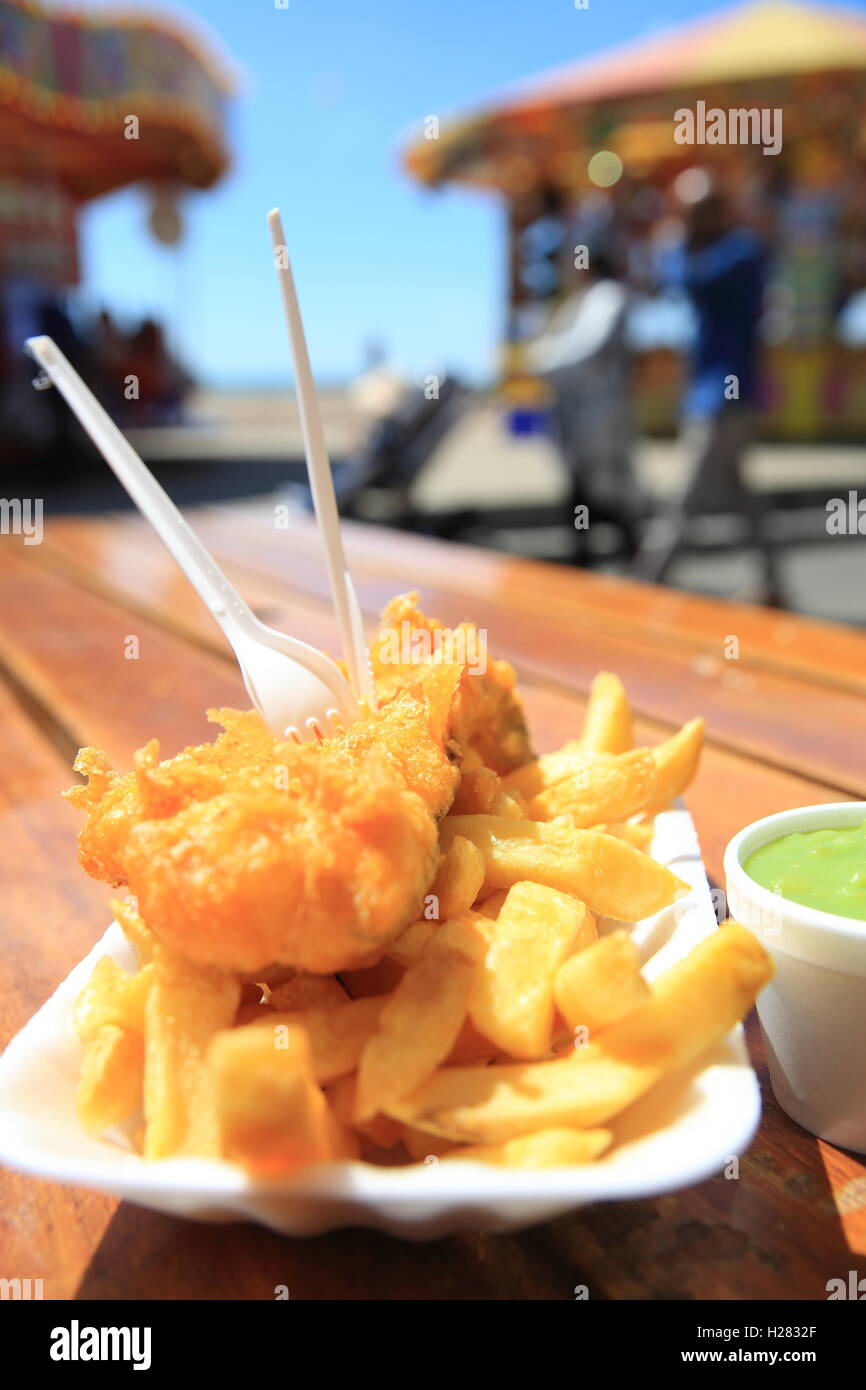 Traditional fish, chips, and a side of mushy peas, on the Brighton seafront, in East Sussex, England, UK Stock Photo