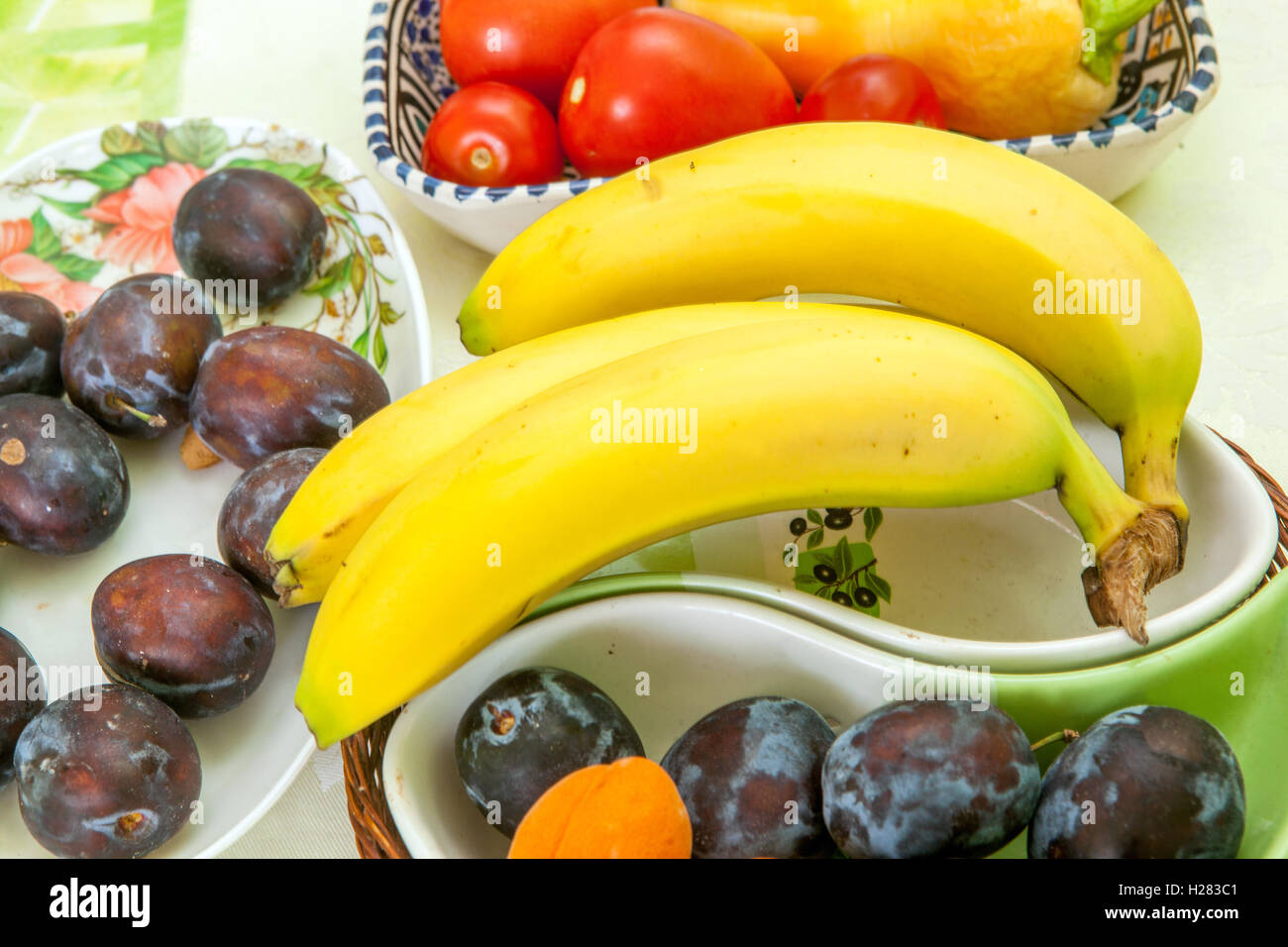 Bananas, plums on table Stock Photo