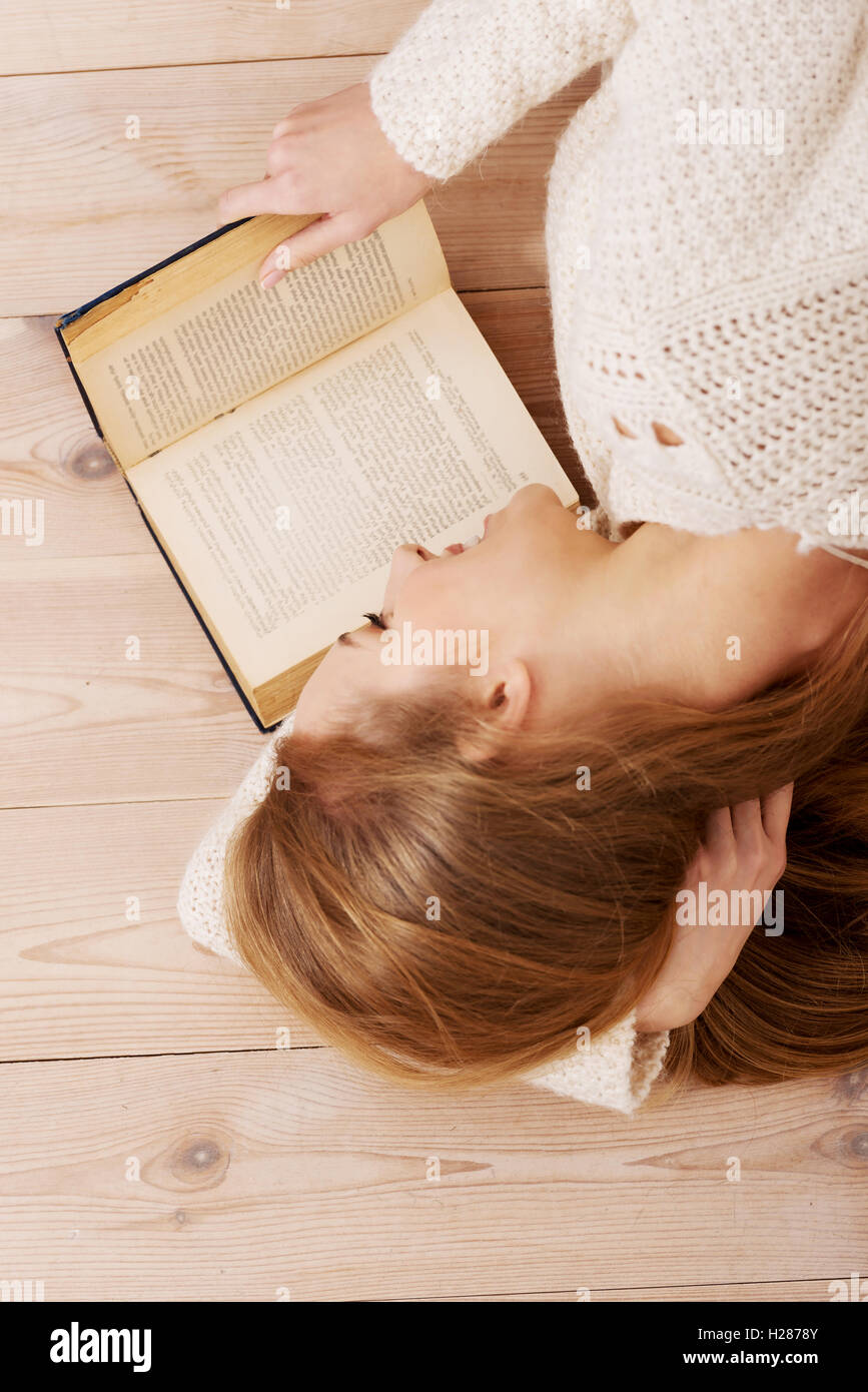 Young beautiful woman lying on the floor with books Stock Photo - Alamy