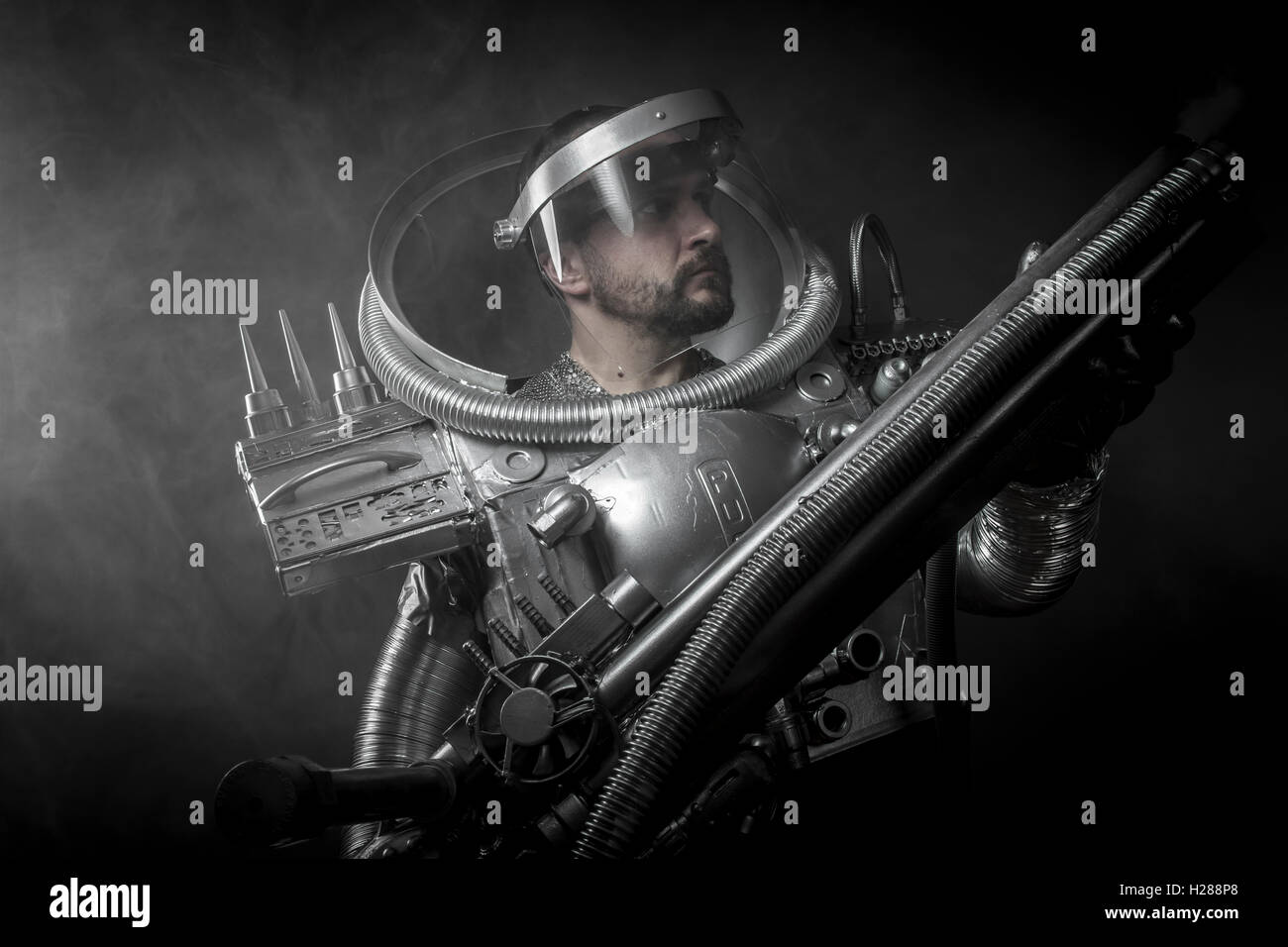 Cosmonaut, Astronaut on a black background with huge weapon. Stock Photo