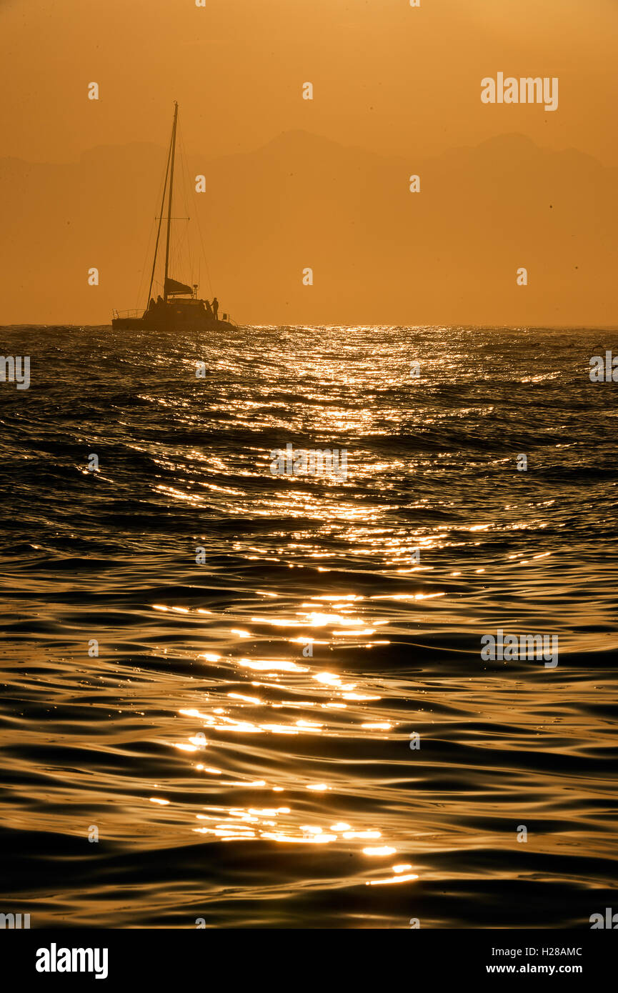 Sailboat at sunrise Stock Photo - Alamy