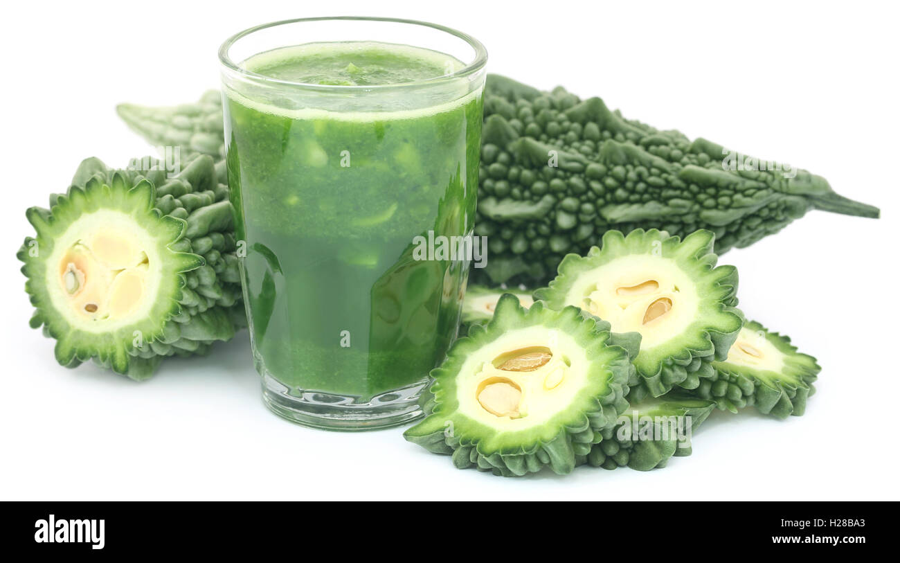 Green momodica with juice in a glass over white background Stock Photo