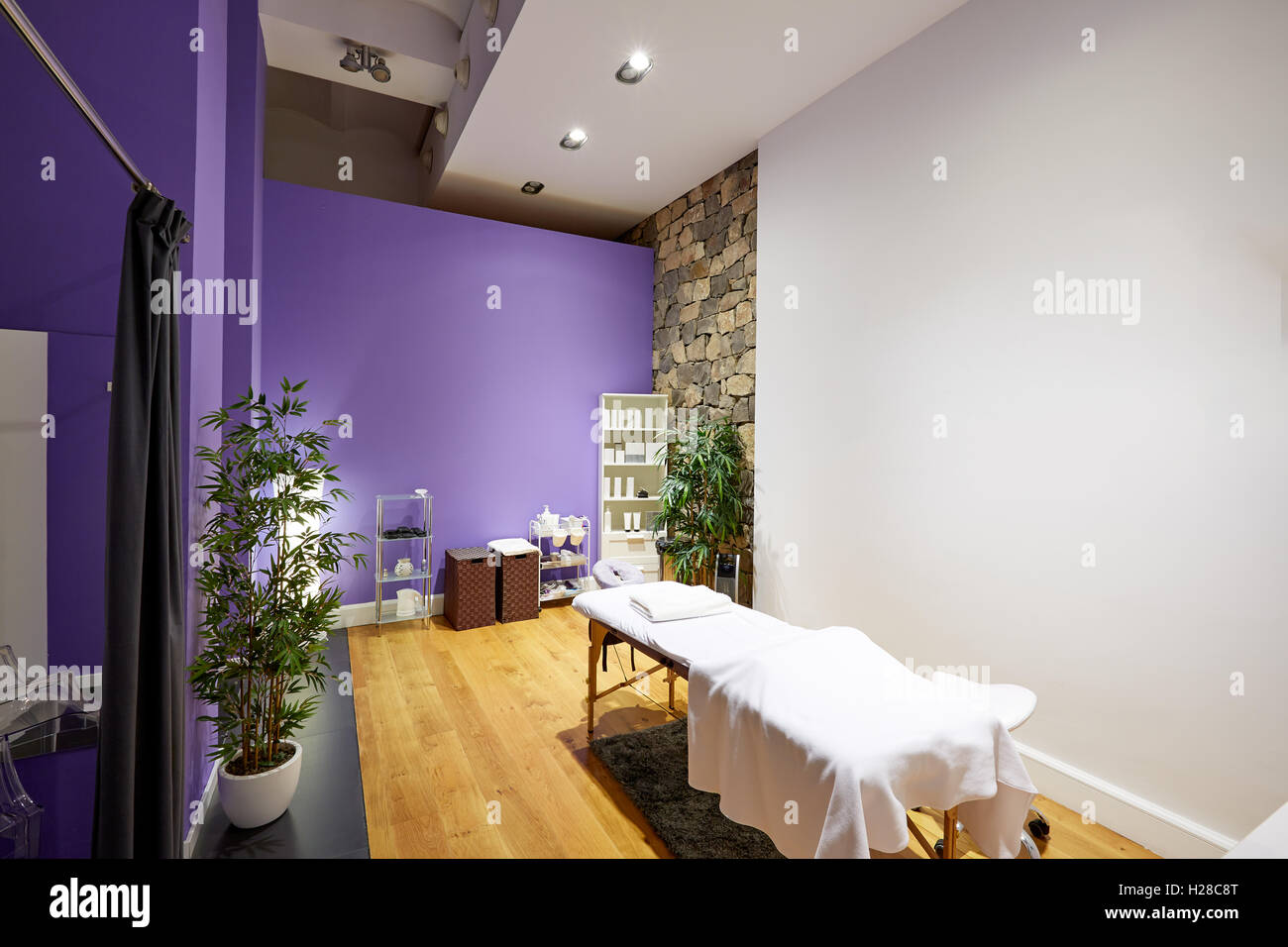 Massage room with massage table and products with stone wall Stock Photo