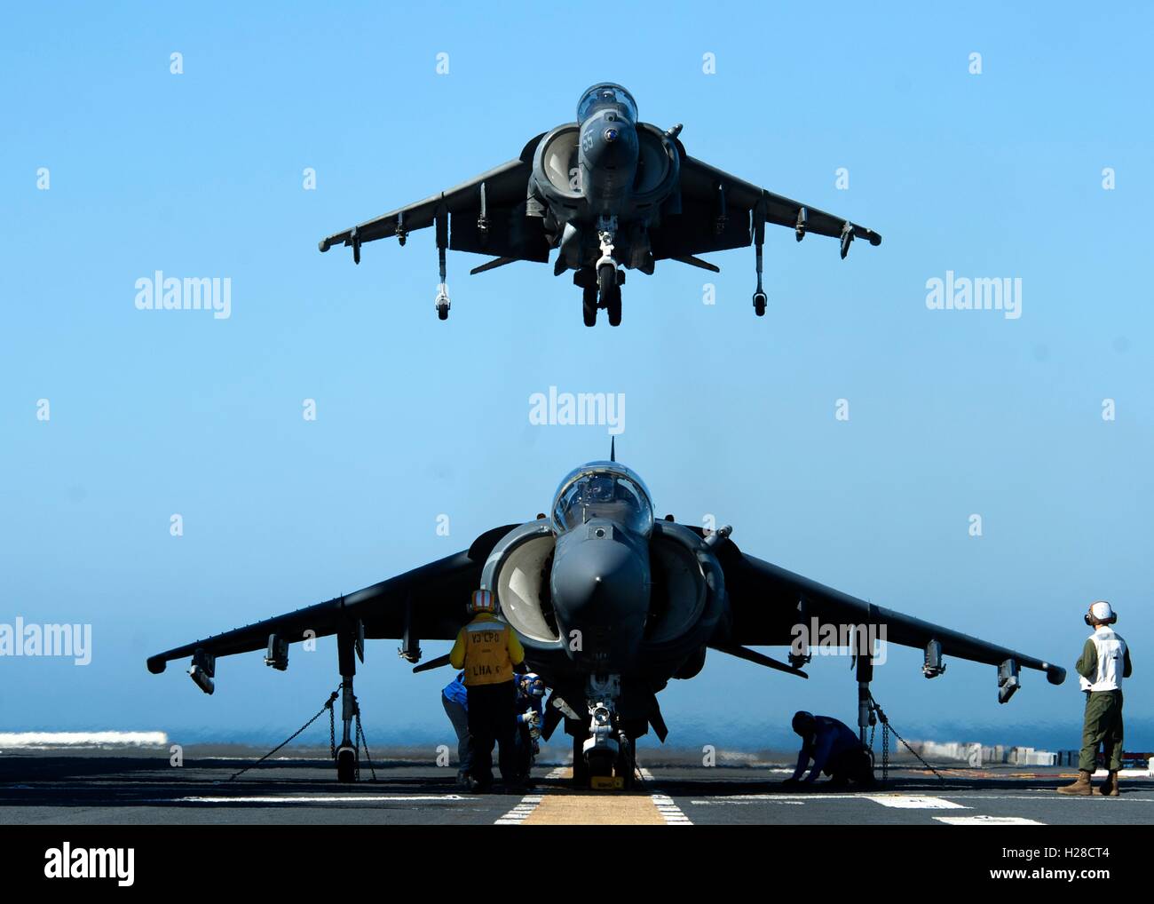 U.S. Marines AV-8B Harrier aircraft prepares to land on the flight deck of the America-class amphibious assault ship USS America during training operations February 26, 2015 in the Pacific Ocean. Stock Photo