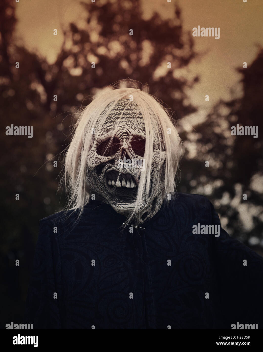 A white scary ghost zombie is outside at night with trees in the background for a decoration or halloween concept. Stock Photo