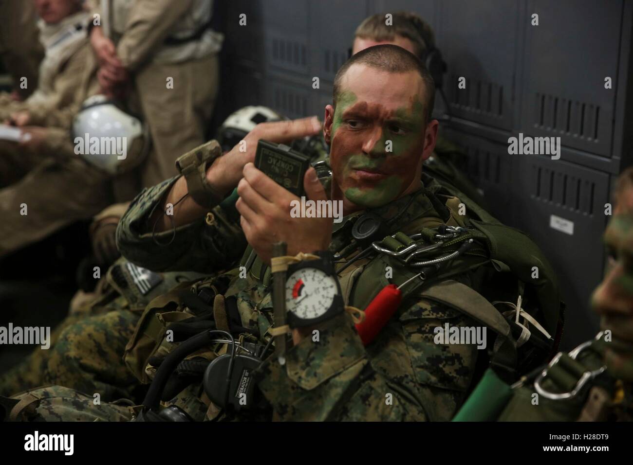 A U.S. Marine paints his face with camouflage in preparation for a mission March 1, 2015 of the coast of San Diego, California. Stock Photo