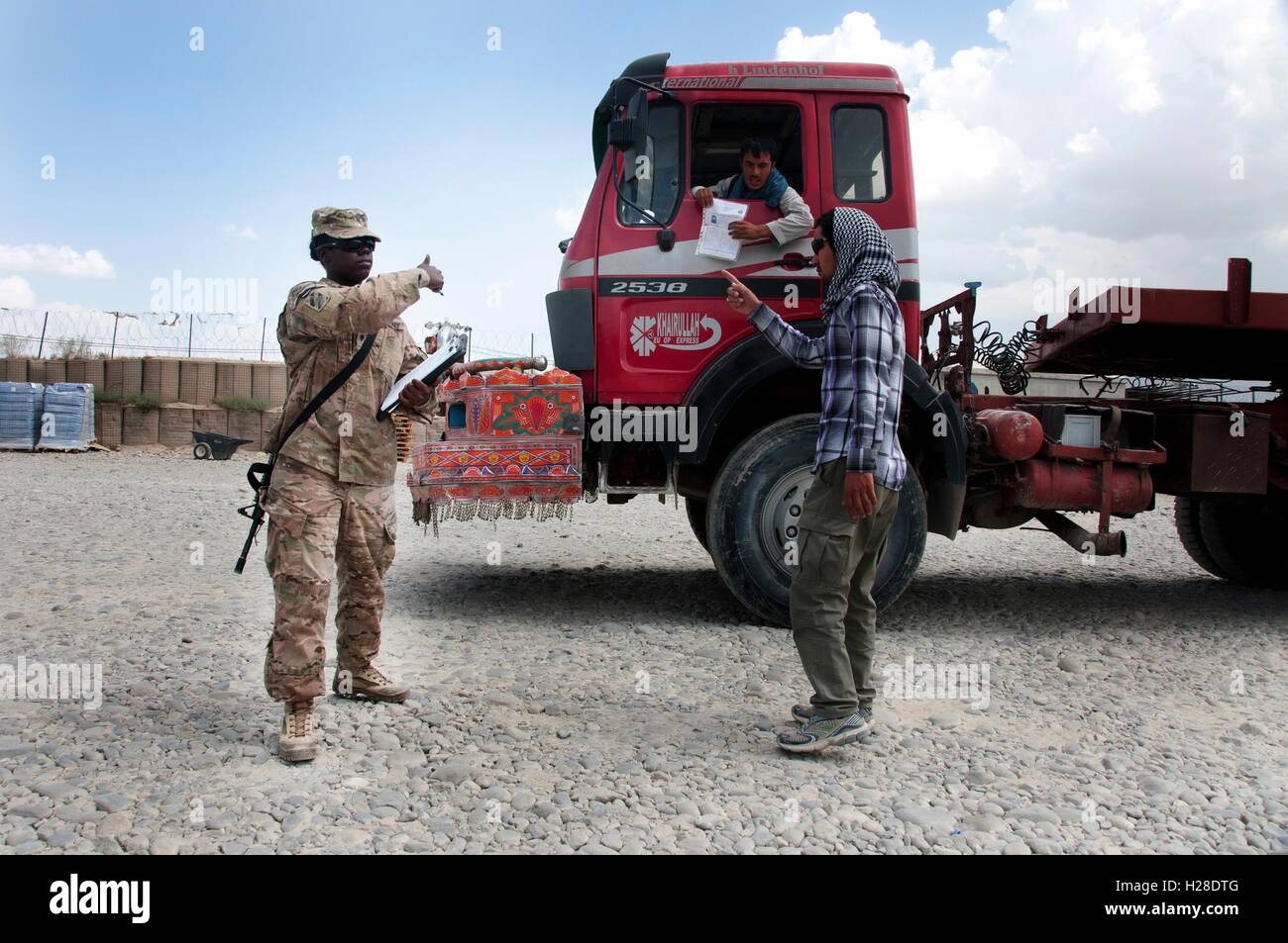 A U.S. Army soldier allows Afghani truck drivers to pass through the Bagram Airfield September 8, 2014 in the Parwan province, Afghanistan. Stock Photo