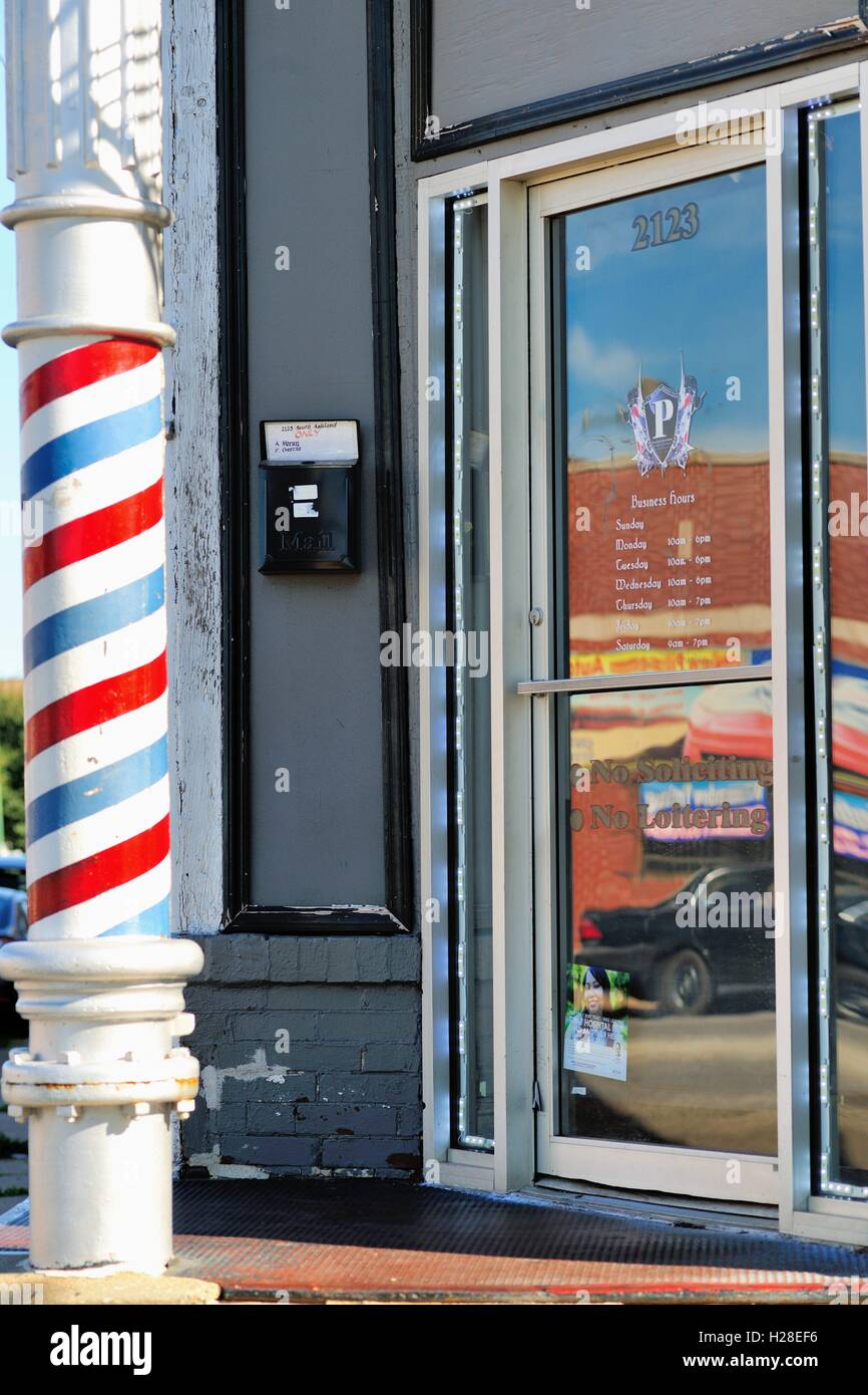 A column decorated as an old-fashioned barber pole serves to identify a shop located in Chicago's Pilsen neighborhood. Chicago, Illinois, USA. Stock Photo