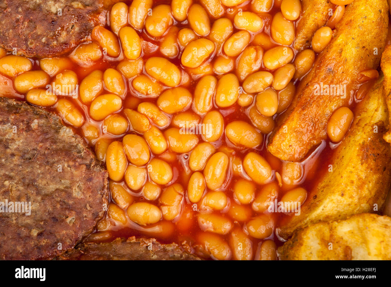 Close up shot of  beef burgers with golden brown potato wedges and baked beans Stock Photo