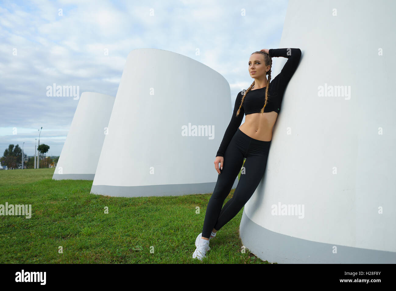 Concept: healthy lifestyle, sport. Attractive happy girl fitness trainer do outdoor workout at modern downtown urban area during Stock Photo