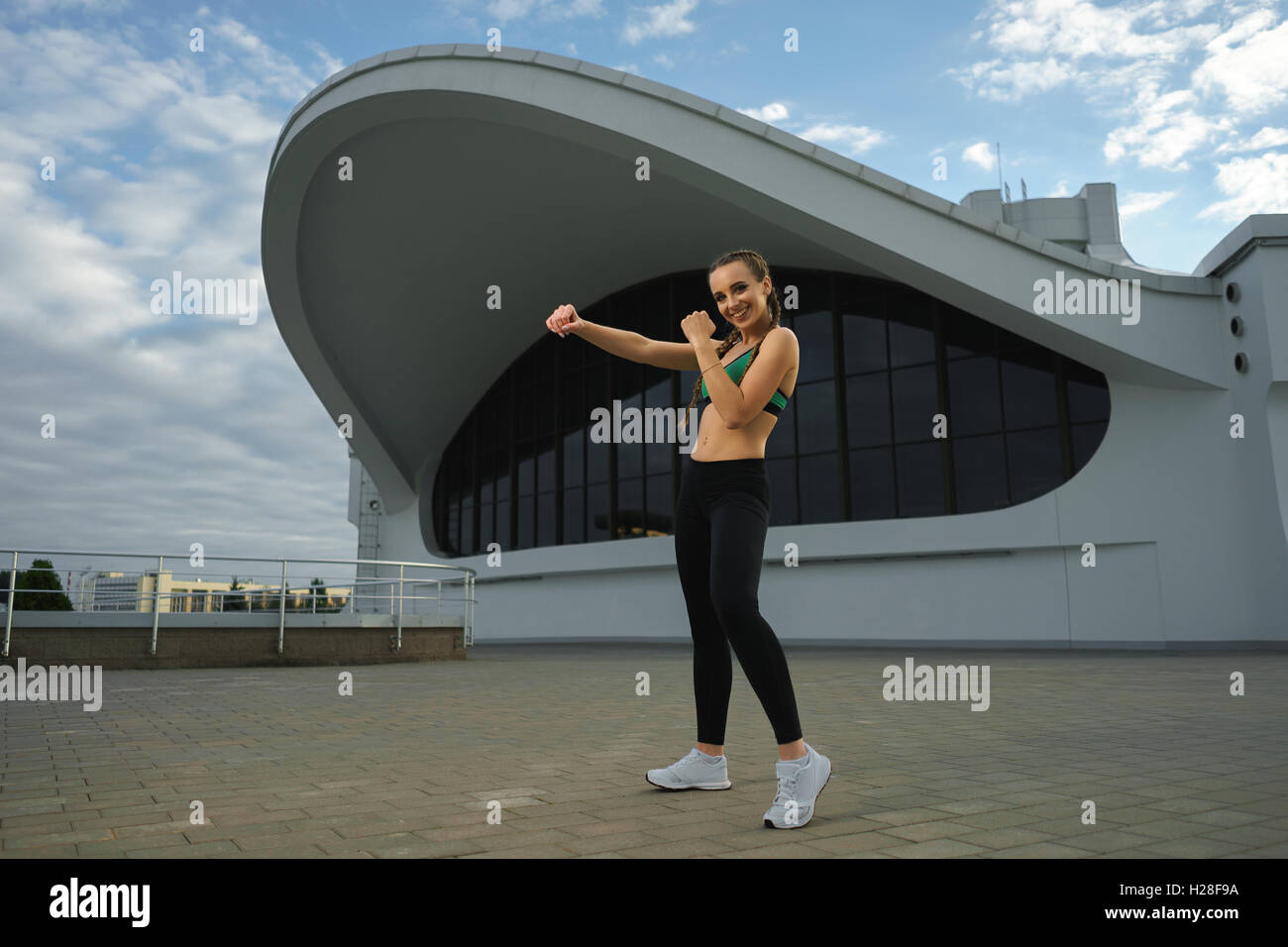 Concept: healthy lifestyle, sport. Attractive happy girl fitness trainer do outdoor workout at modern downtown urban area during Stock Photo