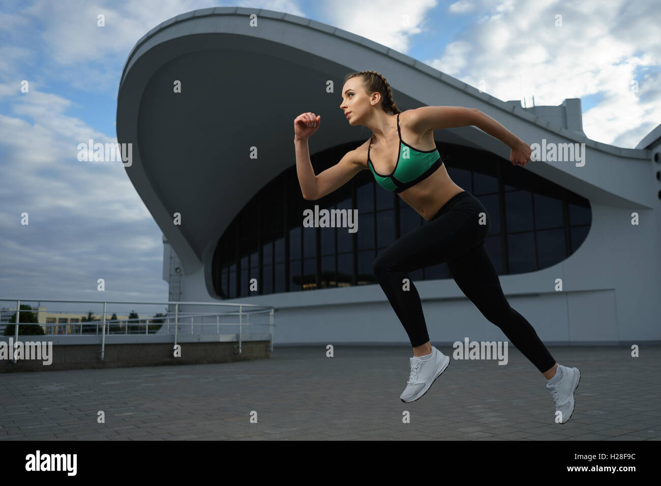 Concept: healthy lifestyle, sport. Attractive happy girl fitness trainer run outdoor workout at modern downtown urban area durin Stock Photo