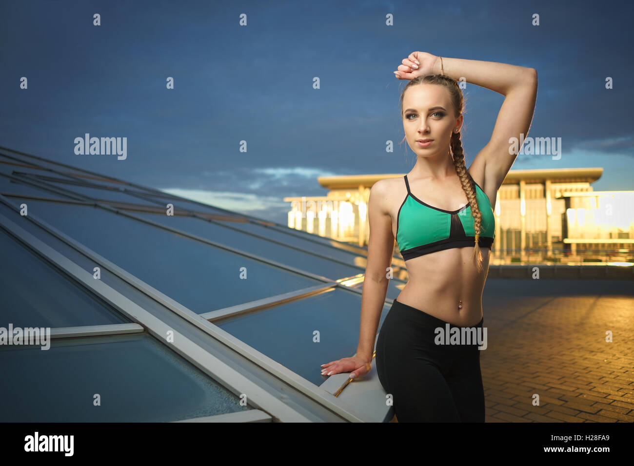 Concept: healthy lifestyle, sport. Attractive happy girl fitness trainer do outdoor workout at modern downtown urban area during Stock Photo