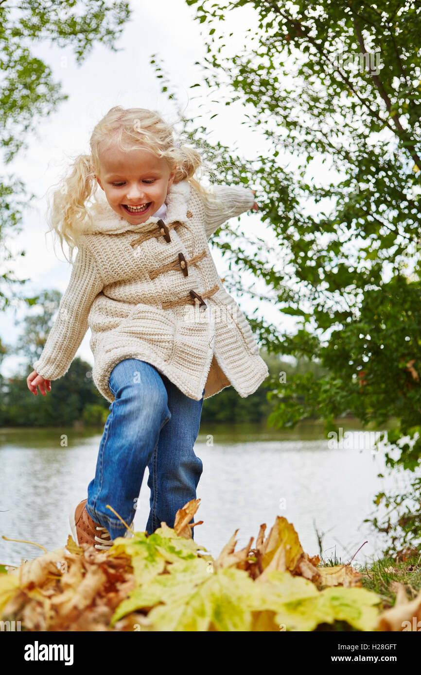 Blond girl playing with leaves in autumn at the park Stock Photo - Alamy