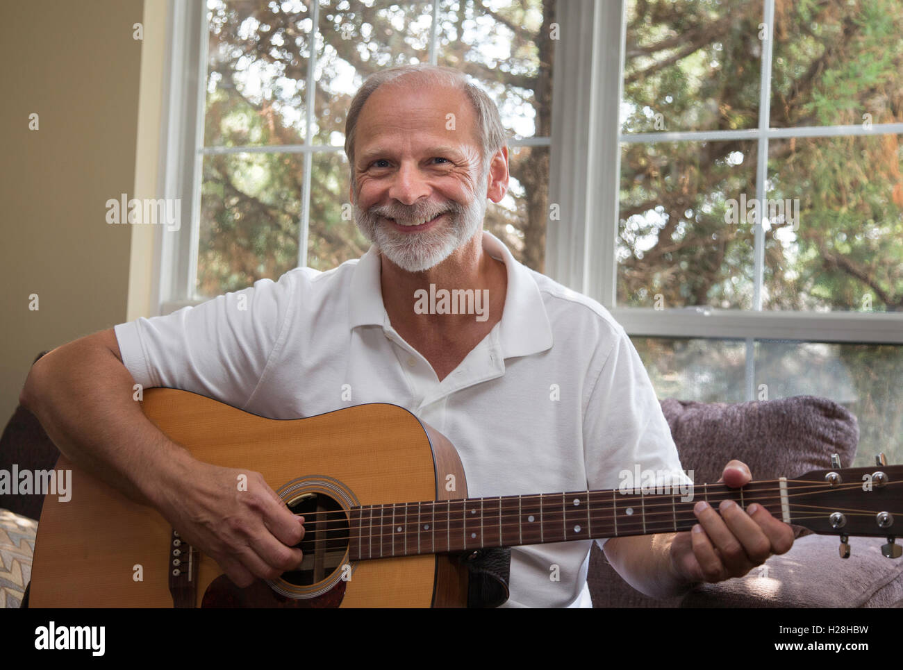 Man playing guitar in his apartment Stock Photo