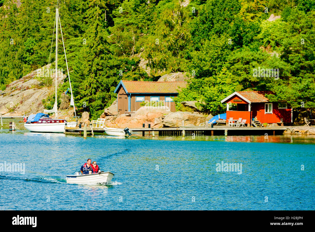 Askeron, Sweden - September 9, 2016: Environmental documentary of adult couple traveling in small open motorboat in the west coa Stock Photo