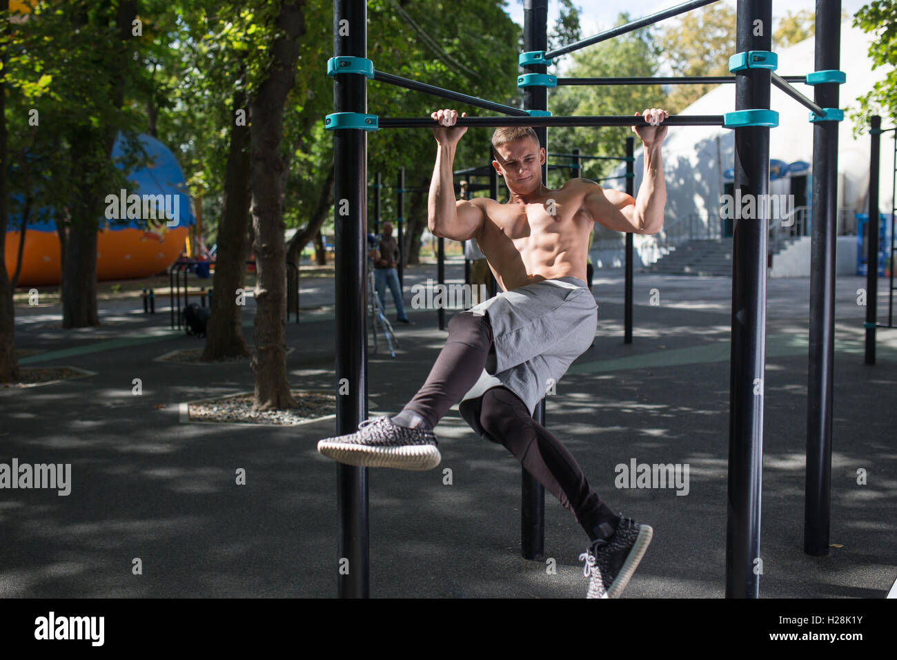 Young man doing pull ups on horizontal bar outdoors, workout, sp Stock ...