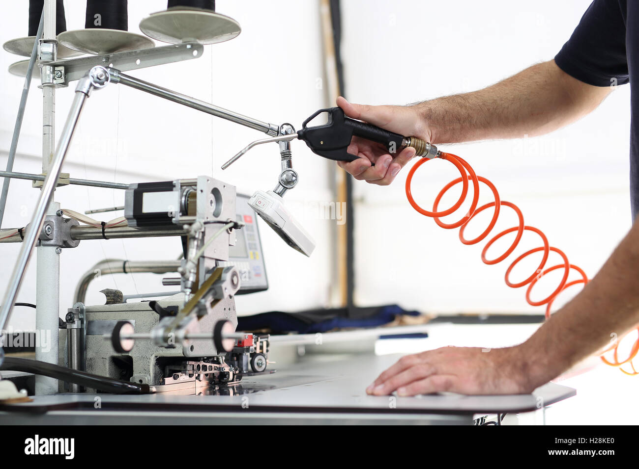 The production plant, cleaning the sewing machine worker cleans the