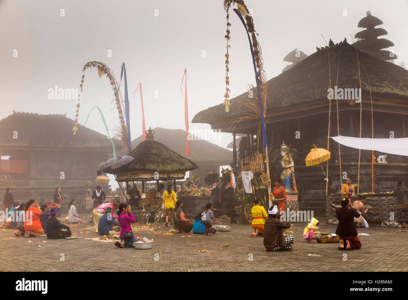 Indonesia, Bali, Batur, Pura Ulun Danu Batur, Kuningan festival worshippers praying in early morning low cloud Stock Photo