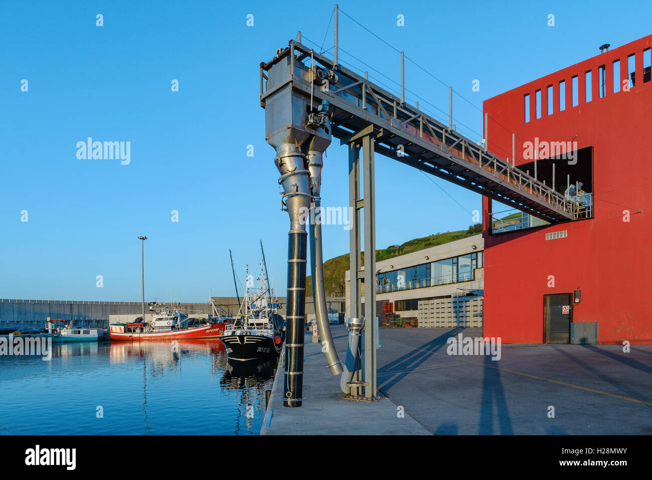 Vacuum extractor to offload fishing boat in the fishing port of Laredo, Village of Cantabria, Spain, Europe Stock Photo