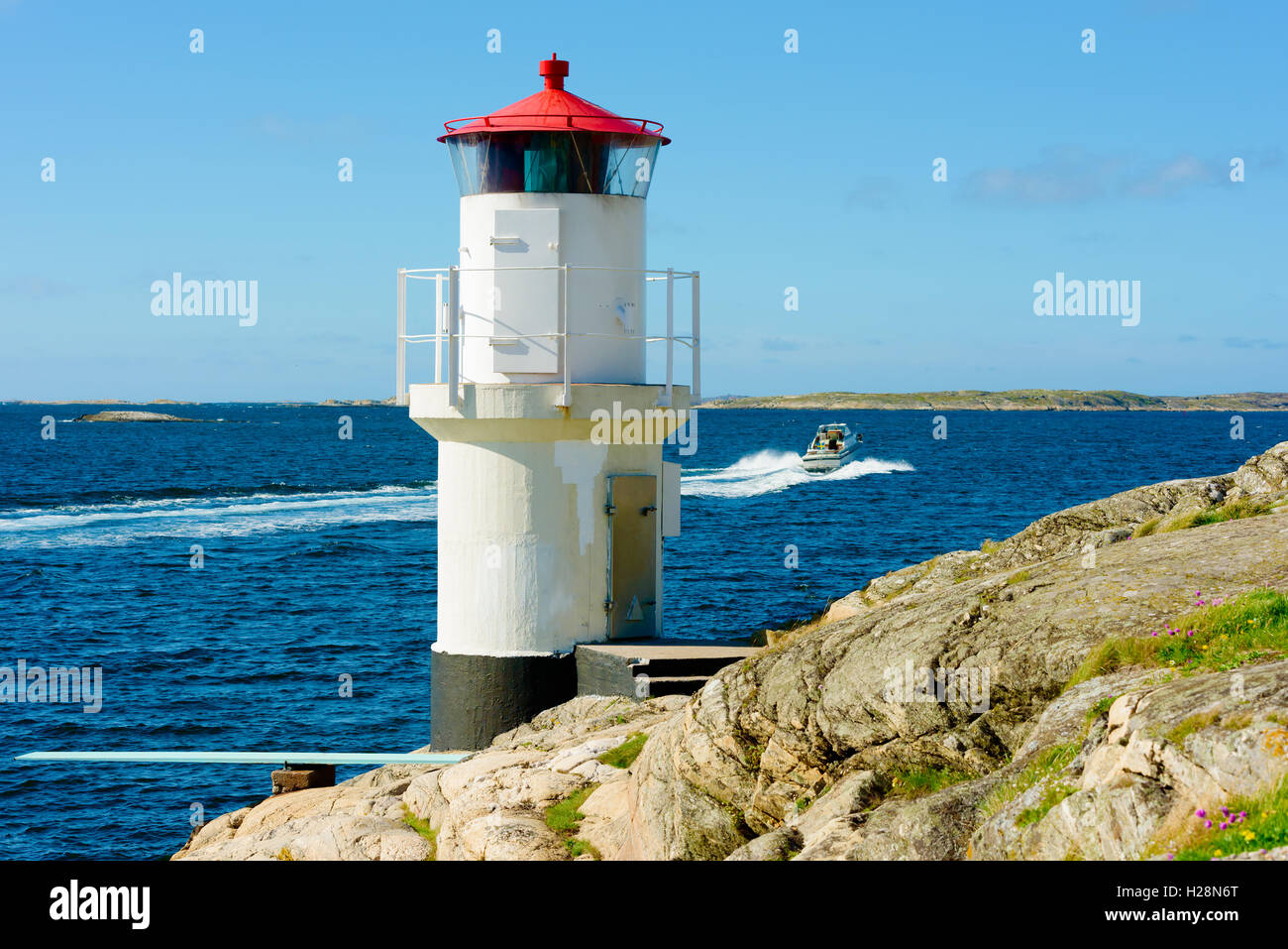 Mollosund, Sweden - September 9, 2016: Environmental documentary of lighthouse with motorboat leaving for a trip in the archipel Stock Photo