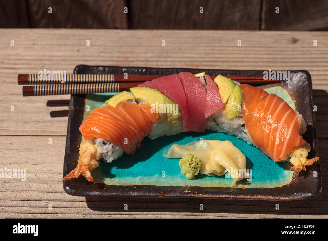 Dragon roll sushi with salmon, tuna, avocado, shrimp tempura and rice