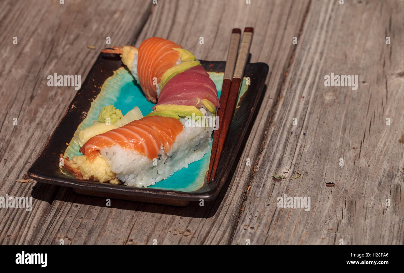 Dragon roll sushi with salmon, tuna, avocado, shrimp tempura and rice