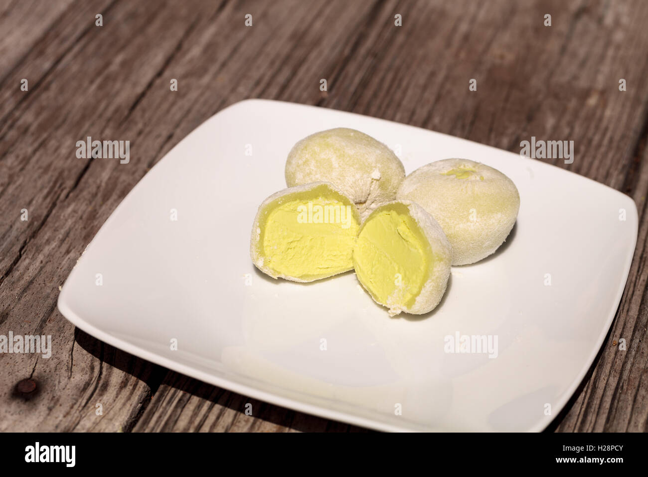 Green tea mochi ice cream bonbon desert on a white plate Stock Photo
