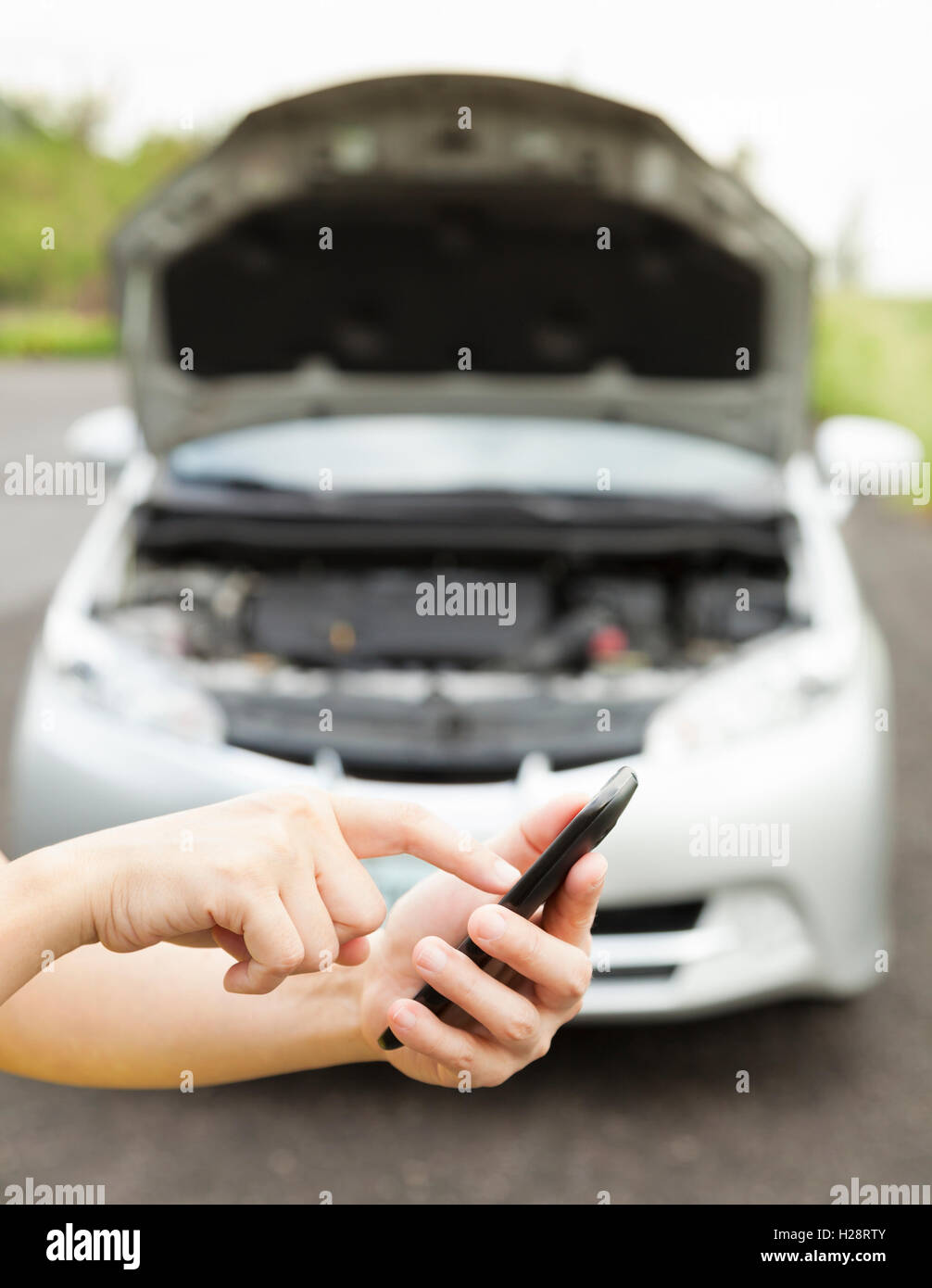 using cell phone to dial service number , a broken car Stock Photo - Alamy
