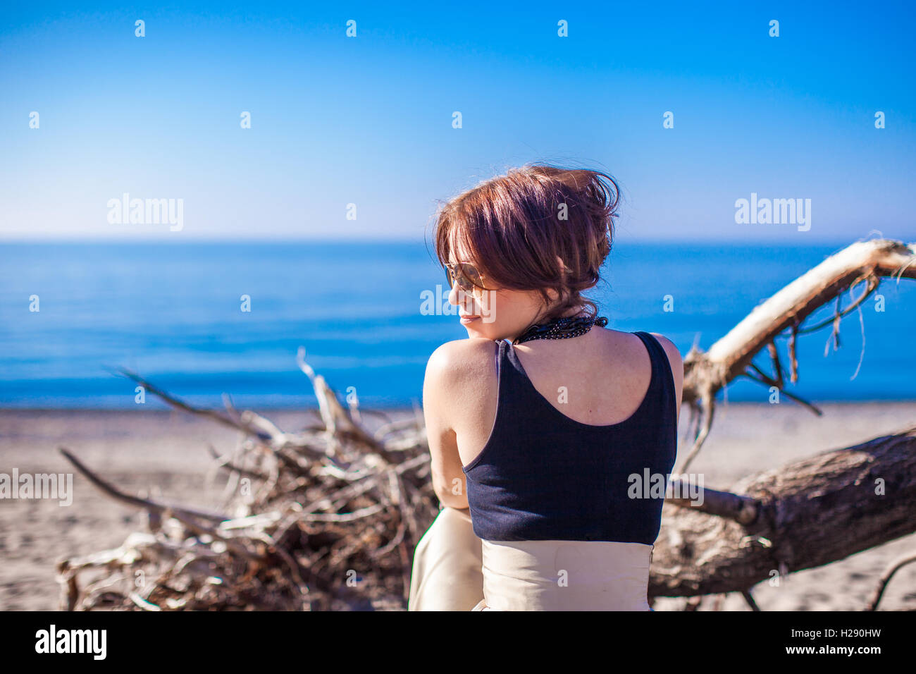 Beautiful young woman relax on the beach in winter sunny day alone ...