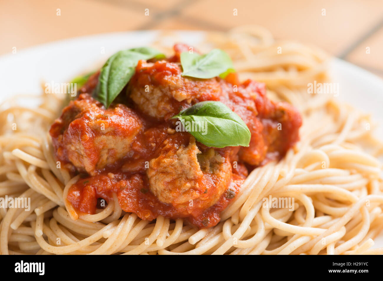 Healthy source of protein vegetarian meat balls Quorn chunks in a tomato sauce with basil leaves and spaghetti Stock Photo