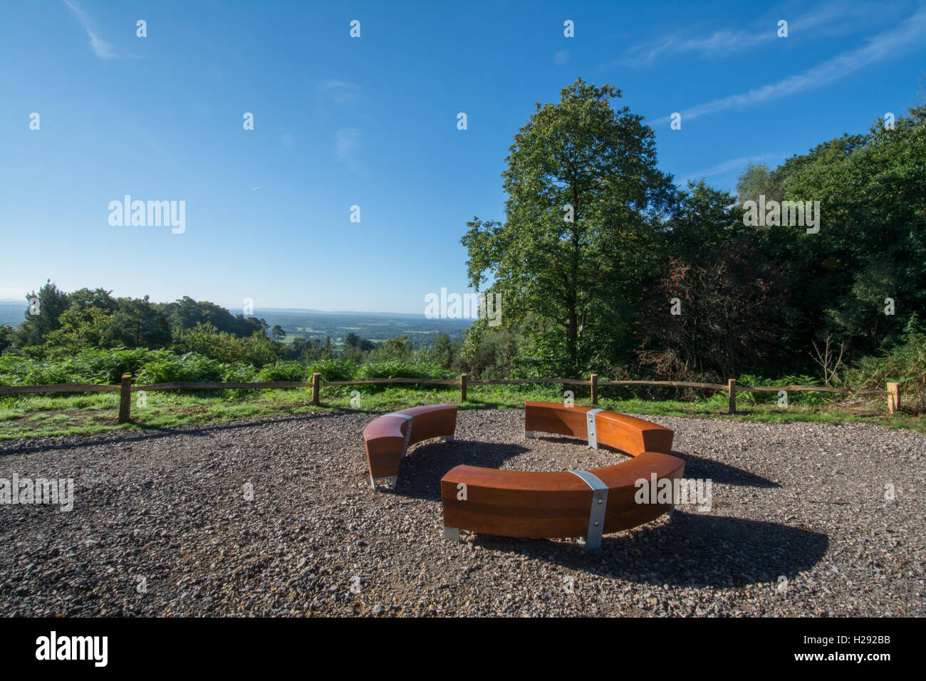 View from Holmbury Hill in the Hurtwood in the Surrey Hills, England, with circular bench seat - art installation called Converse by Matthew Burt Stock Photo