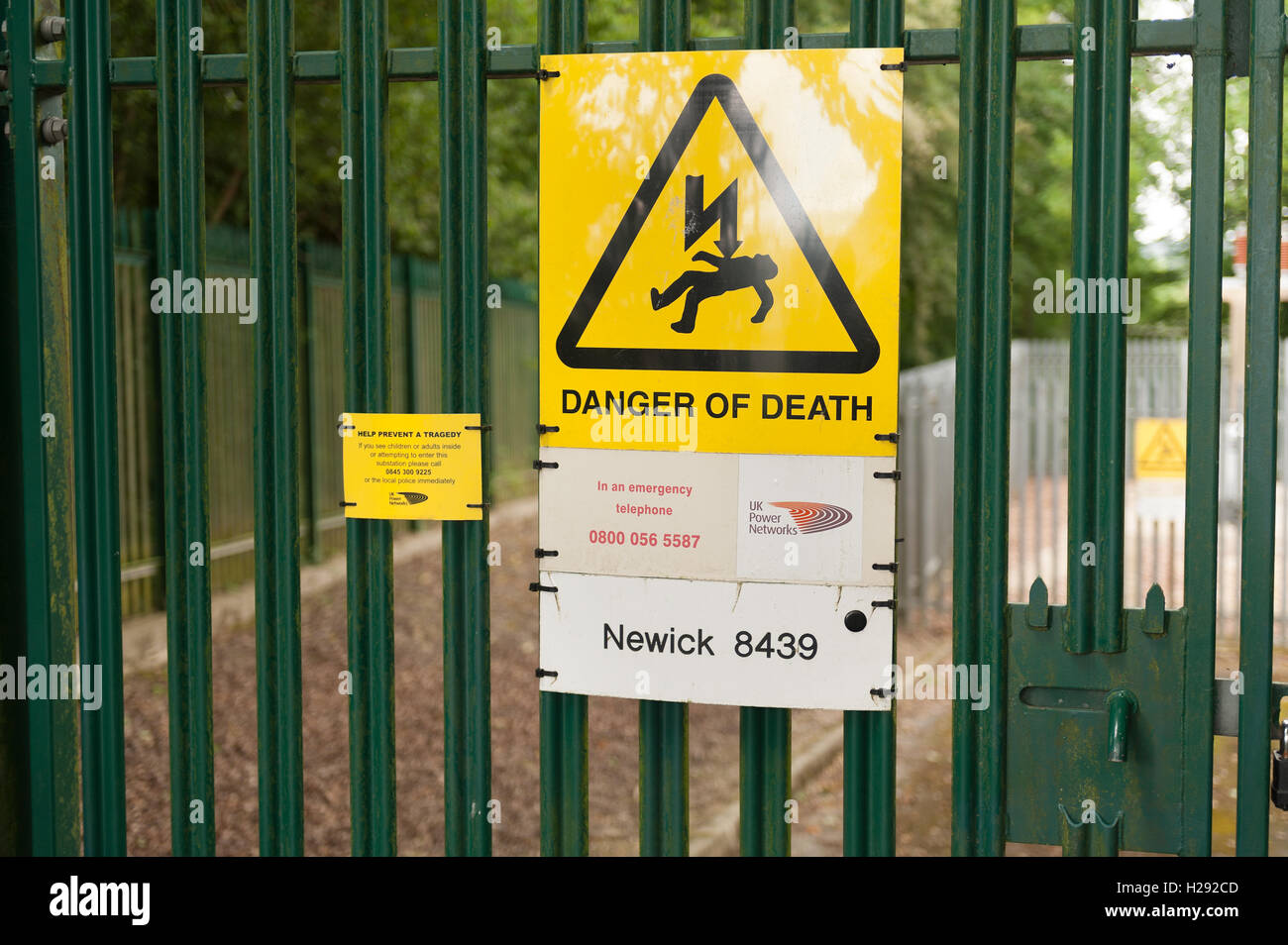 strong metallic metal wall fence keeping public out away from mains electricity substation 33000 volts danger of death Stock Photo