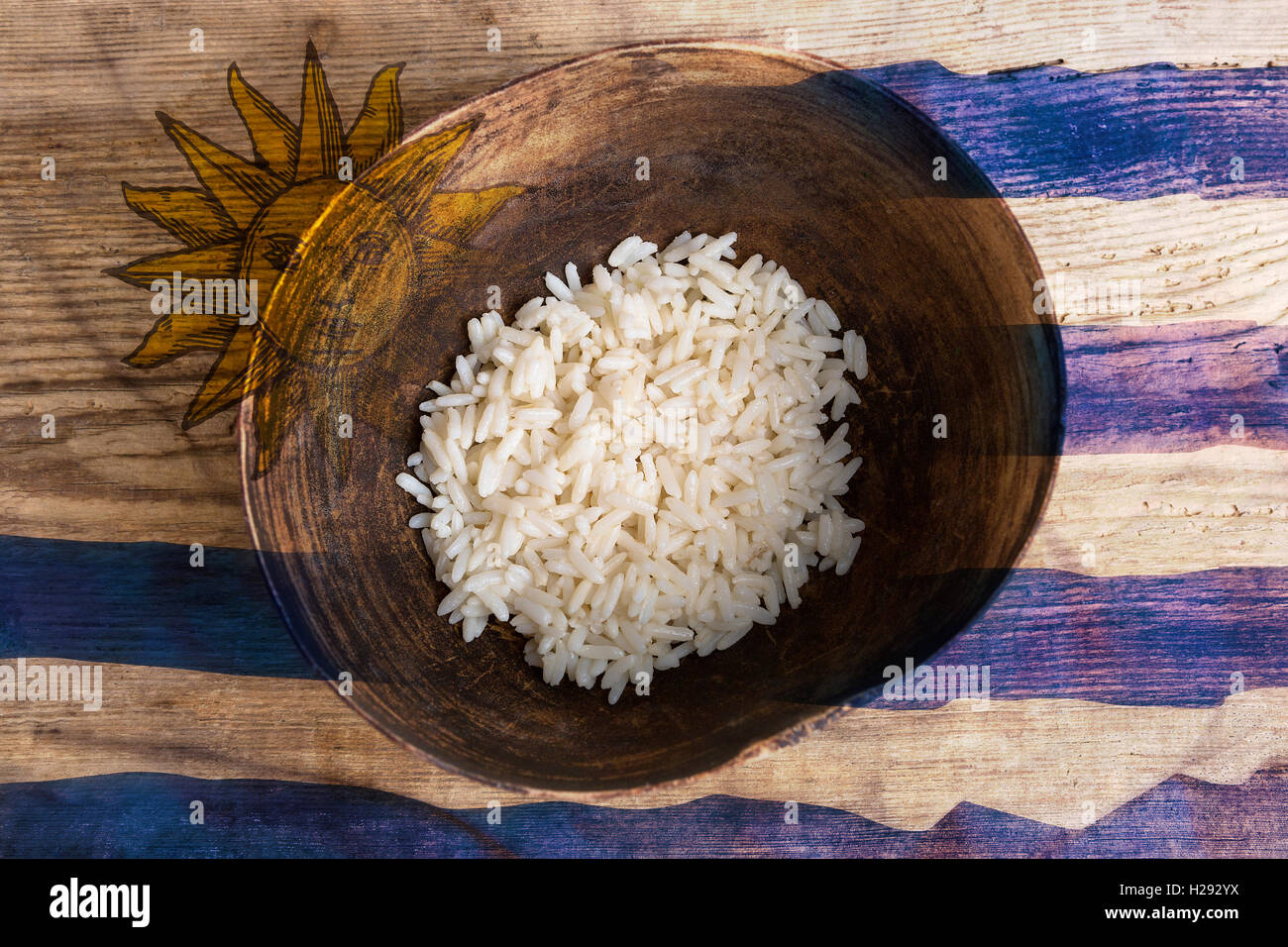 Poverty concept, bowl of rice with Uruguayan flag on wooden background Stock Photo