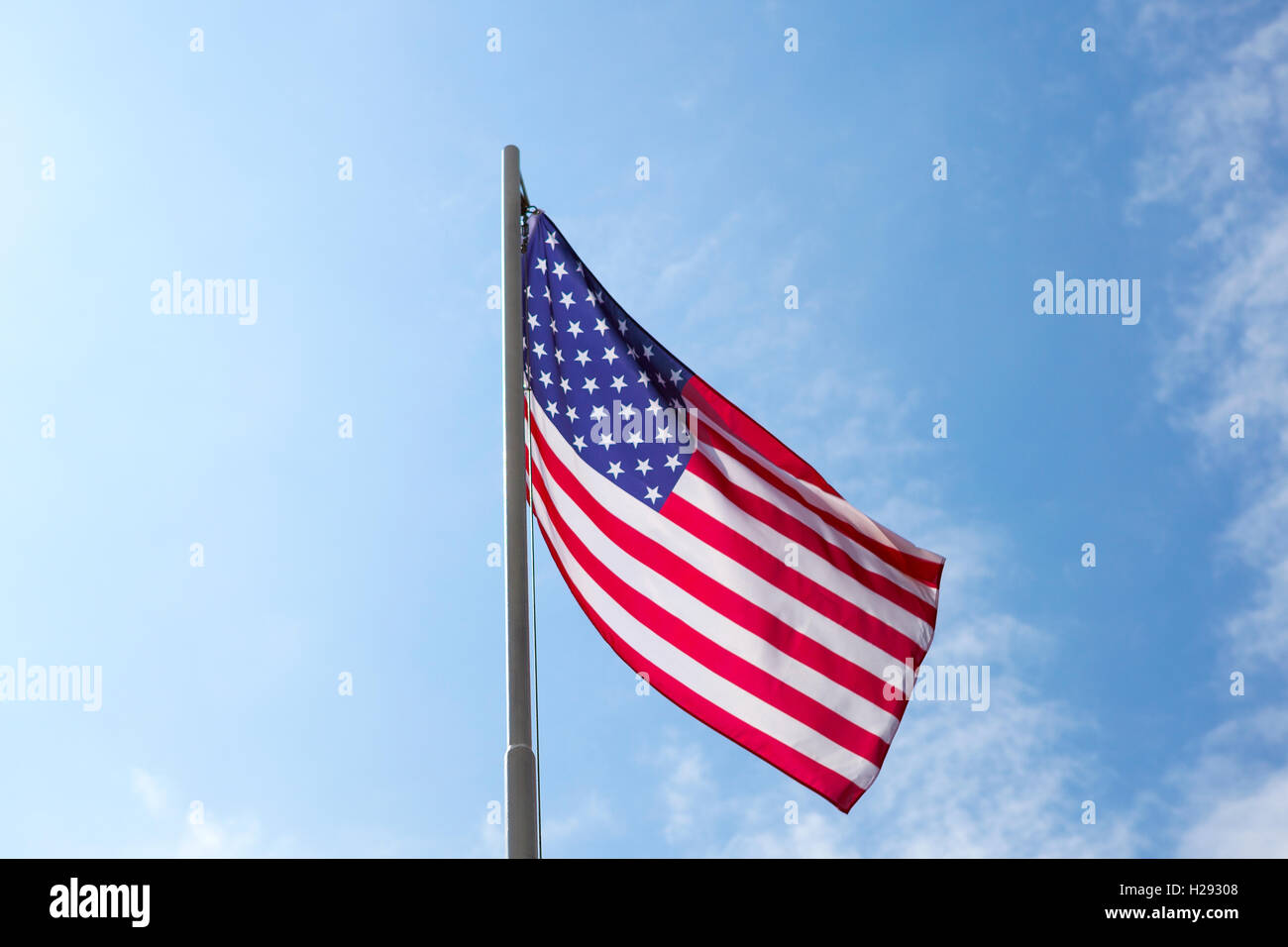 Flag of United States on a flagpole in front of blue sky Stock Photo ...