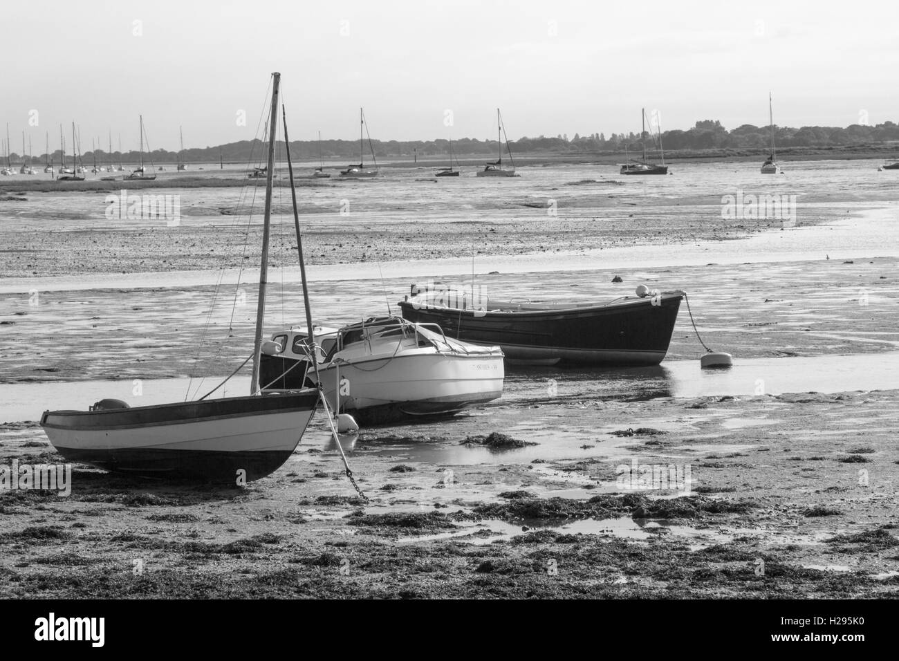 Black and white image of three boats stranded in mud at low tide at Nore Rithe Emsworth Hampshire Uk Stock Photo